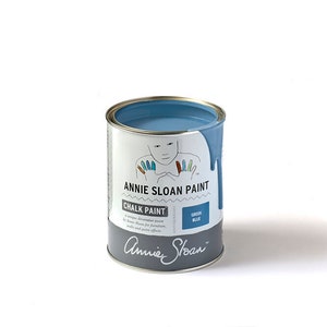 May include: A can of Annie Sloan Chalk Paint in the color Green Blue. The can is open and the paint is visible inside. The can is labeled with the Annie Sloan logo and the name of the color.