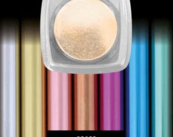 May include: A square, clear container with a circular, golden-colored product inside. The container sits above a row of colorful tubes, with the word "BRASS" in a black rectangle at the bottom. The tubes are various colors, including gold, pink, and blue.
