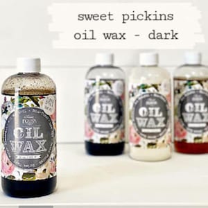 May include: Four bottles of Sweet Pickins Oil Wax in dark, natural, white, and red. The bottles are labeled with a floral design and the text "Sweet Pickins Oil Wax".