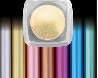 May include: A square, clear container with a gold powder inside. The container is centered above a row of colorful tubes in shades of silver, gold, pink, copper, purple, blue, and green. The word "GOLD" is printed in white on a black label.