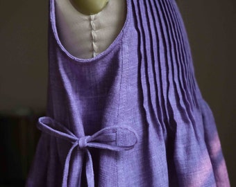 May include: A purple linen dress with a pleated bodice and a bow tie at the waist.