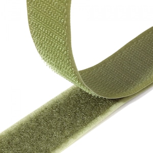 May include: A close-up of olive green hook and loop fastener tape. The tape is folded over on itself, showing the hook side and the loop side.