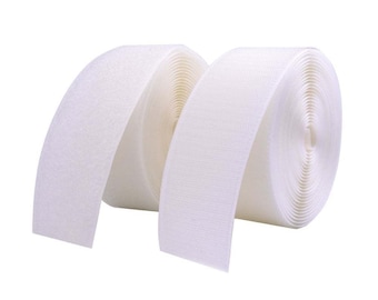 May include: Two rolls of white hook and loop tape, also known as Velcro, are shown. The tape is rolled up and the ends are unrolled, showing the texture of the fabric.