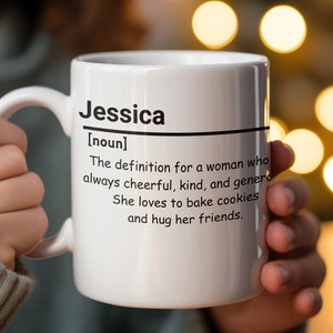 Peut inclure: Une tasse en céramique blanche avec une poignée noire. La tasse a du texte noir qui dit "Jessica [nom] La définition d'une femme qui est toujours joyeuse, gentille et généreuse. Elle adore faire des biscuits et faire des câlins à ses amis."