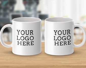 May include: Two white ceramic mugs with black text that reads "YOUR LOGO HERE" on each mug.