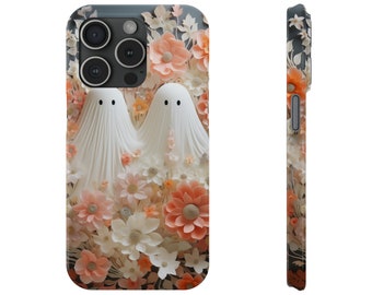 Puede incluir: Funda de teléfono con un diseño de dos figuras de fantasmas blancos rodeadas de flores melocotón, blancas y naranjas. La funda tiene un fondo gris oscuro y un acabado brillante. El diseño es floral.