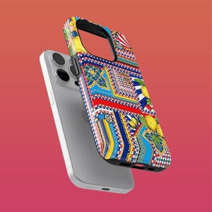 Peut inclure: Un iPhone blanc avec une coque de téléphone à motifs colorés. La coque présente un motif géométrique avec des citrons, des fleurs et des accents bleus et rouges.
