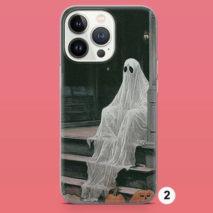 May include: A white ghost sitting on a porch with two pumpkins. The ghost is wearing a white sheet and has a white face. The porch is made of wood and has a dark brown color. The pumpkins are orange and have a carved face. The background is a dark green color.