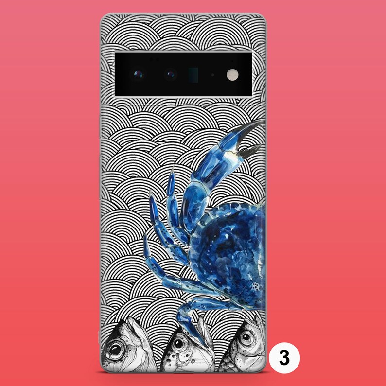 Op de afbeelding: Een telefoonhoesje met een zwart-wit patroon van overlappende cirkels. Een blauwe krab bevindt zich op het hoesje, met opgeheven scharen. Drie vissen bevinden zich aan de onderkant van het hoesje.