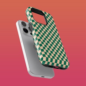 Può includere: Una custodia per telefono a scacchi verdi e beige per un iPhone. La custodia è realizzata in un materiale resistente e ha un design elegante.