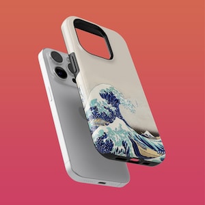 Può includere: Una custodia bianca per iPhone con un design a onde blu e bianche. La custodia presenta un'opera d'arte di ispirazione giapponese di un'onda gigante che si infrange contro una montagna.