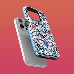 Peut inclure: Une coque de téléphone iPhone blanche avec un motif floral bleu et rouge. La coque a un bord surélevé autour de l'objectif de l'appareil photo et une surface texturée.
