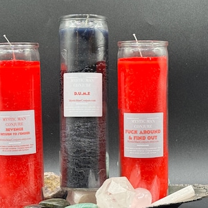 Puede incluir: Tres tarros de velas de vidrio rojo y negro con etiquetas blancas. Las etiquetas tienen el texto "Mystic Man Conjure" y diferentes frases. Las velas están en una bandeja plateada con piedras blancas y rosas.