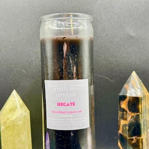 May include: A black glass candle with a white label that reads "Mystic Man Conjure" and "Hecate" with the website "MysticManConjure.com".
