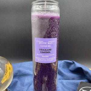 Puede incluir: Una vela de vidrio púrpura con una etiqueta que dice "Mystic Man Conjure Command Control MysticManConjure.etsy.com" y el texto "Nunca deje una vela encendida sin vigilancia. Enciéndala en un recipiente resistente al calor. Contiene hierbas y aceites, por lo que debe evitar el contacto con los muebles."
