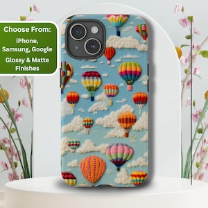 May include: A phone case with a colorful hot air balloon design on a blue background. The case has a cutout for the camera lens and is available in glossy and matte finishes.