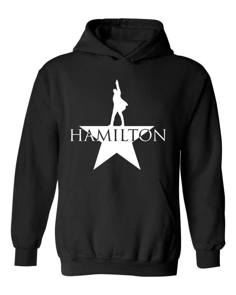 May include: Black hooded sweatshirt with a white silhouette of a person standing on a star with the word "HAMILTON" printed below.