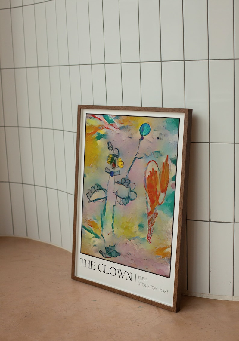 May include: A framed abstract painting titled "THE CLOWN" by Emma Stockton 2023. The painting features a colourful, whimsical style with a blue balloon, a yellow flower, and a figure resembling a clown in a blue hat.