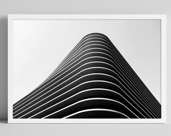 Puede incluir: Fotografía en blanco y negro de un edificio moderno con una fachada curva. El edificio está formado por líneas horizontales que crean un patrón geométrico.