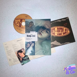 May include: A music album set featuring a CD, album art, and lyric sheet. The CD and album art are brown and black with the text "SKZ-REPLAY" and "Deep end". A photo card with a person is also included.