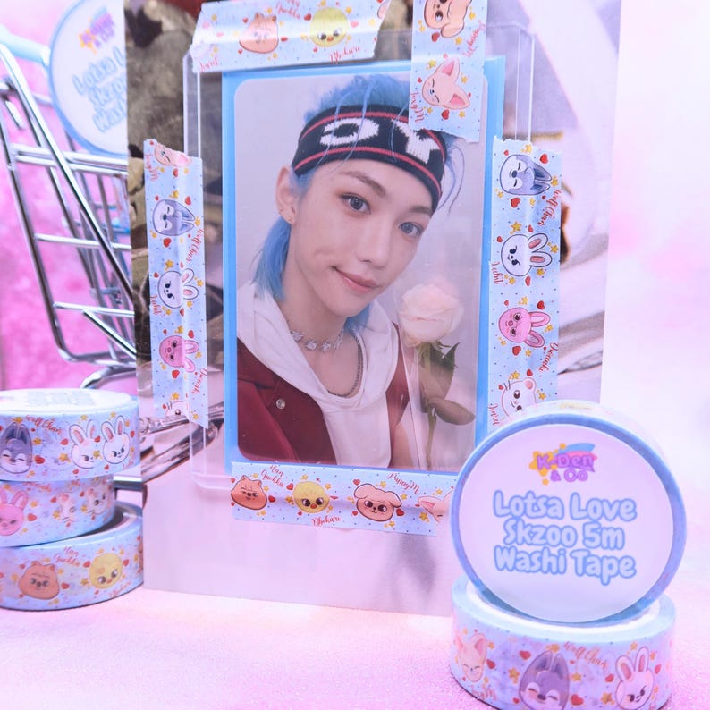 May include: A photo card of a person with blue hair and a headband, holding a rose, is displayed with decorative washi tape. The tape features cartoon animal designs and the text "Lotsa Love Skzoo 5m Washi Tape."