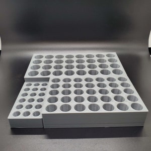 May include: A gray plastic storage organizer with multiple compartments for holding small items. The organizer is made up of two sections, one larger than the other, and has a total of 72 compartments.