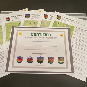 Può includere: Un certificato e diversi fogli informativi per i parchi nazionali dello Utah. Il certificato recita "Certified Utah U.S. National Park Explorer" e presenta i loghi dei parchi. I fogli includono mappe e dettagli per Arches, Bryce Canyon, Canyonlands, Capitol Reef e Zion National Park.