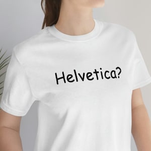 May include: White t-shirt with black text that reads "Helvetica?"