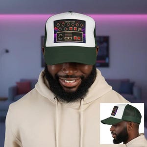 Könnte beinhalten: Eine dunkelgrüne und weiße Trucker-Cap mit einem Grafikdruck eines Retro-Videospiel-Controllers und dem Text KONAMI CODE. Die Kappe hat ein strukturiertes Vorderteil mit weißem Hintergrund sowie einen dunkelgrünen Schirm und Netz-Seitenteile.