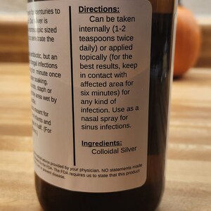 May include: A brown glass bottle with a white label that reads "Directions: Can be taken internally (1-2 teaspoons twice daily) or applied topically (for the best results, keep in contact with affected area for six minutes) for any kind of infection. Use as a nasal spray for sinus infections. Ingredients: Colloidal Silver".