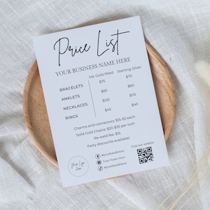 Może przedstawiać: Biała lista cenowa dla biżuterii z tytułem "Price List" i tekstem "YOUR BUSINESS NAME HERE". Lista zawiera ceny bransoletek, bransoletek na kostkę, naszyjników i pierścionków w 14-karatowym złocie i srebrze próby 925. Lista zawiera również ceny zawieszek, łączników i masywnych złotych łańcuszków. Lista zawiera kod QR i uchwyty mediów społecznościowych.