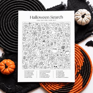 May include: A white rectangular activity sheet titled Halloween Search Can You Find Them All? featuring a black and white line art illustration filled with various spooky icons and a numbered list of items to locate at the bottom of the page.