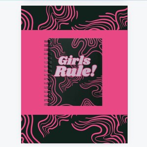 May include: A pink and black spiral notebook with a black cover featuring pink swirling lines and the text "Girls Rule!" in pink letters.