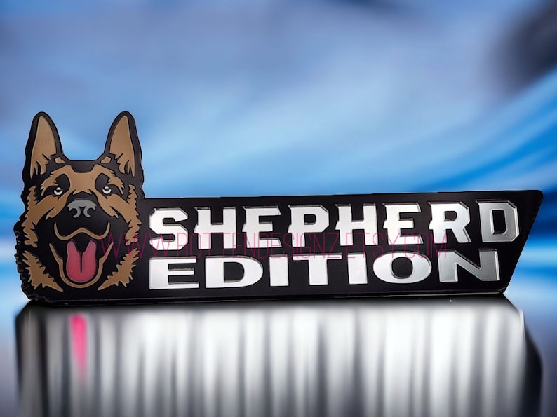 以下が含まれることがあります： ジャーマンシェパードの犬の頭と「SHEPHERD EDITION」の文字が書かれた黒と銀のエンブレムです。