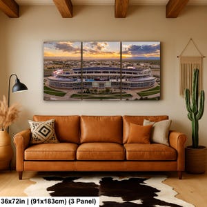 A large, three-panel wall art depicting a stadium with a sunset in the background.