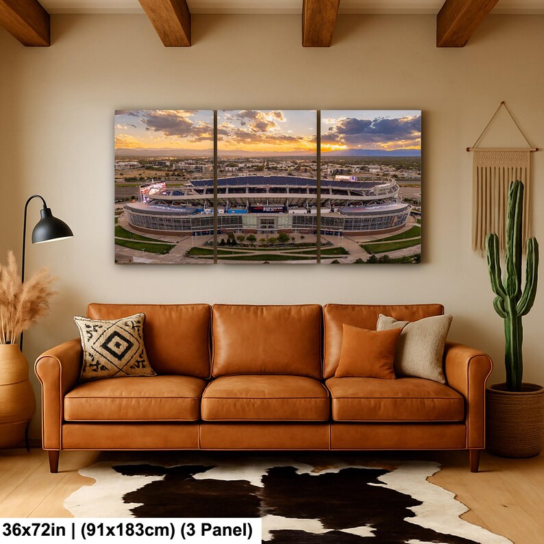 A large, three-panel wall art depicting a stadium with a sunset in the background.