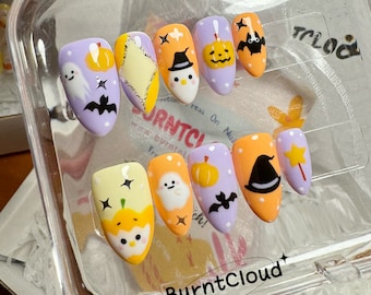May include: A set of ten Halloween-themed nail art designs. The designs feature pumpkins, ghosts, bats, stars, and witches' hats. The designs are painted on a white background.