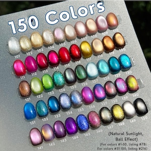 Pode incluir: Uma exibição de 150 cores de verniz de unhas, cada uma em uma amostra em forma de unha. As cores variam de prata e dourado a vermelhos, azuis e roxos vibrantes, com um acabamento brilhante e reflexivo. O texto "150 Colors" está no topo.