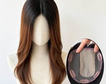 以下が含まれることがあります： 根元がダークブラウンで、毛先に向かって明るいチェスナットブラウンに変化するロングストレートのヘアトッパー。円形のインセット画像には、中央のメッシュベースと複数の小さな金属製クリップが付いたヘアピースの裏側が写っています。