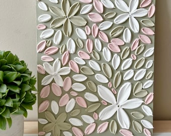 Puede incluir: Pintura abstracta sobre lienzo con una superficie texturizada y en relieve. La pintura presenta un patrón de flores rosas, blancas y verdes sobre un fondo verde salvia.