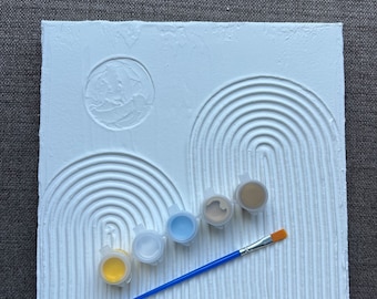 May include: White canvas with raised lines forming arches, a circle, and a brush. Five small paint pots with yellow, white, light blue, dark blue, and brown paint.