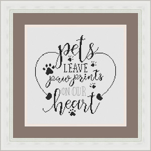 Puede incluir: Patrón de punto de cruz en blanco y negro con forma de corazón y el texto "Las mascotas dejan huellas de patas en nuestro corazón".