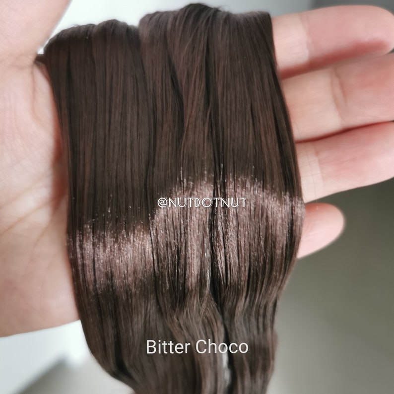 May include: Close-up of a bundle of dark brown embroidery floss, labeled "Bitter Choco".