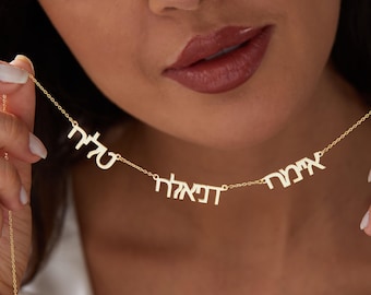 May include: Gold necklace with three Hebrew words, "אהבה", "שלום", and "חיים", meaning "love", "peace", and "life".