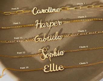 May include: Five gold necklaces with different chain styles and personalized nameplates. The names on the necklaces are Caroline, Harper, Gabriela, Sophia, and Ellie. Each name is written in a different font style.
