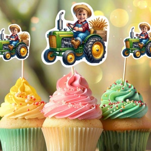 K&ouml;nnte beinhalten: Drei Cupcakes, verziert mit gr&uuml;nem, rosa und gelbem Frosting. Jeder Cupcake hat einen gr&uuml;nen, gelben und schwarzen Traktor-Topper mit einem kleinen Jungen in einem Strohhut, der den Traktor f&auml;hrt.