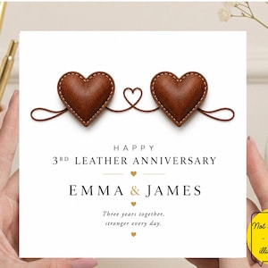 May include: A square greeting card featuring two brown leather-textured hearts connected by a thin brown line with a small heart in the centre. The text reads: HAPPY 3RD LEATHER ANNIVERSARY, EMMA & JAMES, Three years together, stronger every day.