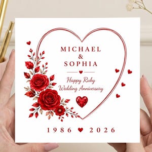 May include: A square greeting card with a white background featuring a large red heart outline. The text reads MICHAEL & SOPHIA, Happy Ruby Wedding Anniversary, and 1986 2026. A cluster of red roses and small red hearts decorate the left side.