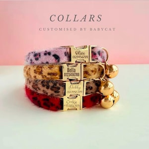 May include: Four pet collars stacked on top of each other. The collars are pink, tan, brown, and red with animal print patterns. Each collar has a gold buckle with a pet's name and phone number. Gold bells hang from the collars. The word "COLLARS" is at the top.