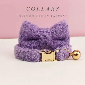 Op de afbeelding: Paarse, pluche kattenhalsband met een strik en een gouden bel. Het halsband heeft een gouden gesp.